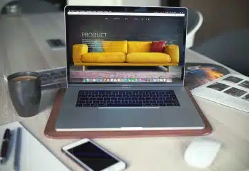 turned on MacBook Pro beside gray mug
